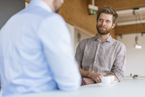 Two businessmen talking in break room - DIGF03804