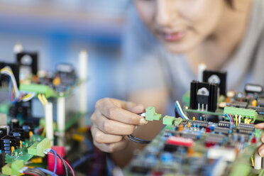 Detail einer Frau, die an einem Motherboard arbeitet - ZEF15282