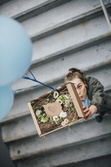 Frau sendet Geschenk in Karton mit Luftballons - GUSF00612