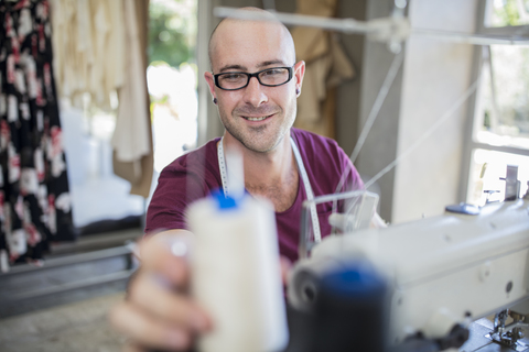 Lächelnde Schneiderin mit Nähmaschine, lizenzfreies Stockfoto