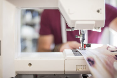 Close-up of man using sewing machine - ZEF15330