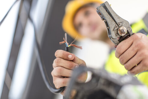 Nahaufnahme eines Elektrikers bei der Arbeit mit einem Drahtschneider - ZEF15340