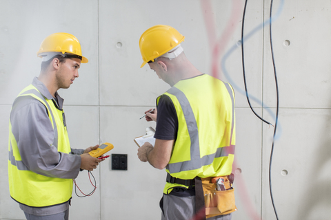 Electricians working on construction site stock photo