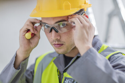 Elektriker setzt Schutzbrille auf - ZEF15351