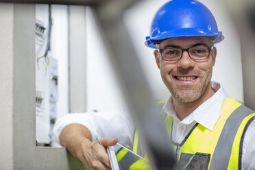 Porträt eines lächelnden Elektrikers am Sicherungskasten - ZEF15358