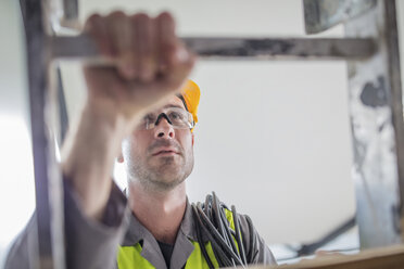 Close-up of construction worker climbing ladder - ZEF15361