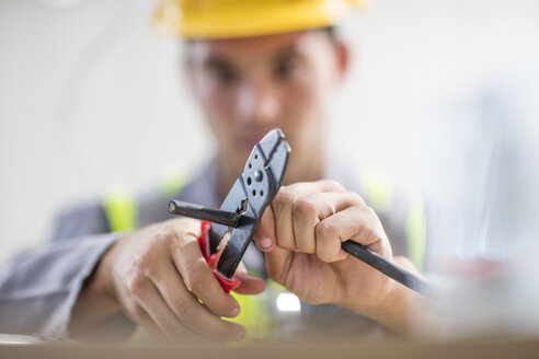 Nahaufnahme eines Elektrikers, der Kabel schneidet - ZEF15364