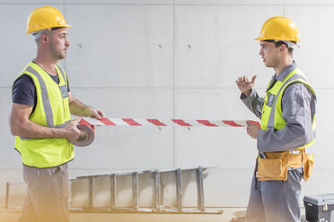 Construction workers using tape on construction site - ZEF15366