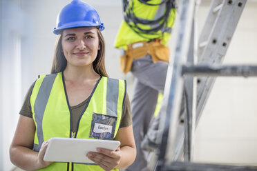 Portrait of smiling woman with tablet on construction site - ZEF15368