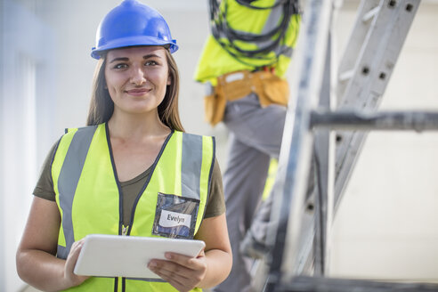 Porträt einer lächelnden Frau mit Tablet auf einer Baustelle - ZEF15368