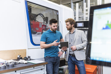 Zwei Männer mit Tablet im Gespräch in einer modernen Fabrik - DIGF03816