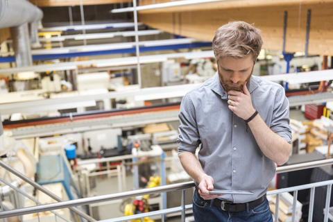 Businessman using tablet in modern factory stock photo