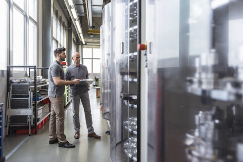 Zwei Männer stehen in einer modernen Fabrik - DIGF03877