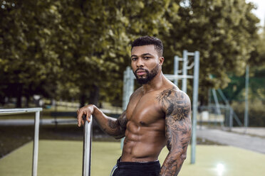 Portrait of tattooed physical athlete on sports field - DAWF00590