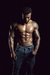 Tattooed physical athlete in front of black background - DAWF00606