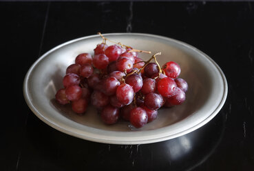 Feuchte rote Weintrauben auf dem Teller - JTF00967