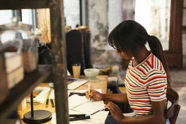 Young woman working at desk in a loft - EBSF02275