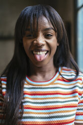 Portrait of laughing young woman sticking out tongue - EBSF02300