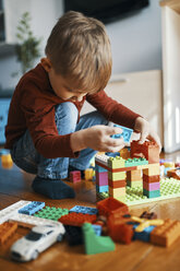 Little boy playing with building bricks on the floor at home - ZEDF01282