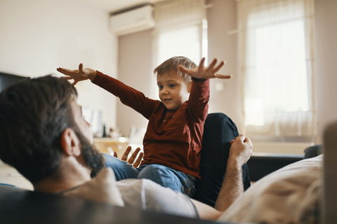 Vater und kleiner Sohn spielen zusammen zu Hause, lizenzfreies Stockfoto