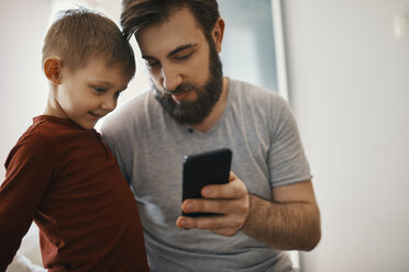 Father explaining little son smartphone - ZEDF01292