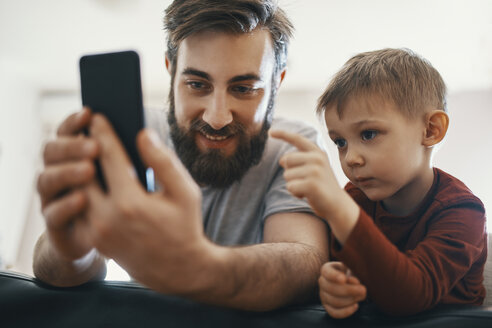 Portrait of father and little son with smartphone - ZEDF01294