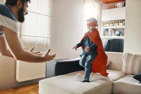 Father playing with his little son dressed up as a superhero at home - ZEDF01322