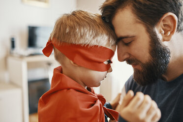 Little boy dressed up as a superhero head to head with his father - ZEDF01324