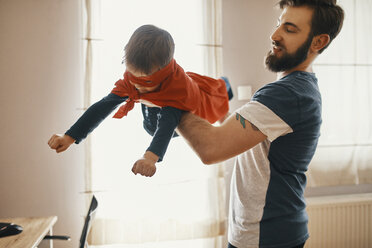 Father playing with his little son dressed up as a superhero - ZEDF01325