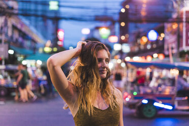 Thailand, Bangkok, junge Frau in der Stadt auf der Straße bei Nacht - AFVF00383