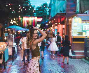 Thailand, Bangkok, junge Frau in der Stadt auf der Straße bei Nacht - AFVF00385