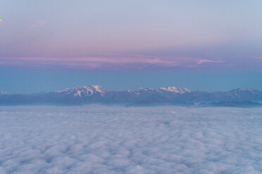 Flug über die Wolken mit Bergen im Hintergrund - AFVF00392