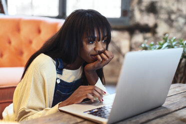 Portrait of smiling young woman using laptop at home - EBSF02332