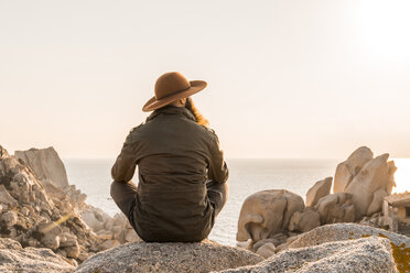 Italy, Sardinia, back view of man wearing hat looking at view - AFVF00406