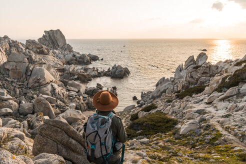 Italien, Sardinien, Rückenansicht eines Wanderers mit Rucksack mit Blick aufs Meer - AFVF00408