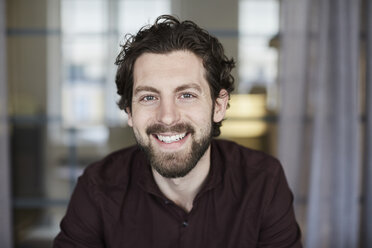 Portrait of smiling businessman standing at creative office - MASF01382