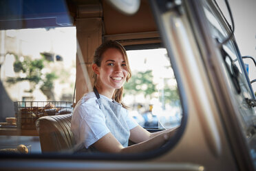 Porträt einer lächelnden jungen Besitzerin eines Imbisswagens in der Stadt - MASF01450