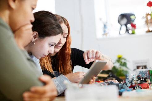 Multiethnische Ingenieurinnen benutzen ein digitales Tablet am Tisch in einer Werkstatt - MASF01489