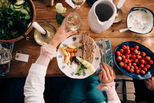 Mittelteil einer Frau, die ein Weinglas hält, während sie ein gesundes Mittagessen in einem Landhaus einnimmt - MASF01492