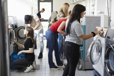 Multiethnische Universitätsstudenten beim Wäschewaschen im Waschsalon - MASF01499