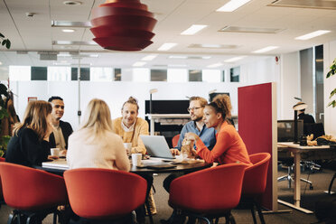 Multiethnische Geschäftskollegen sitzen während einer Besprechung am Konferenztisch im Büro - MASF01508