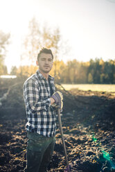 Portrait of confident male farmer with shovel standing on organic farm - MASF01535