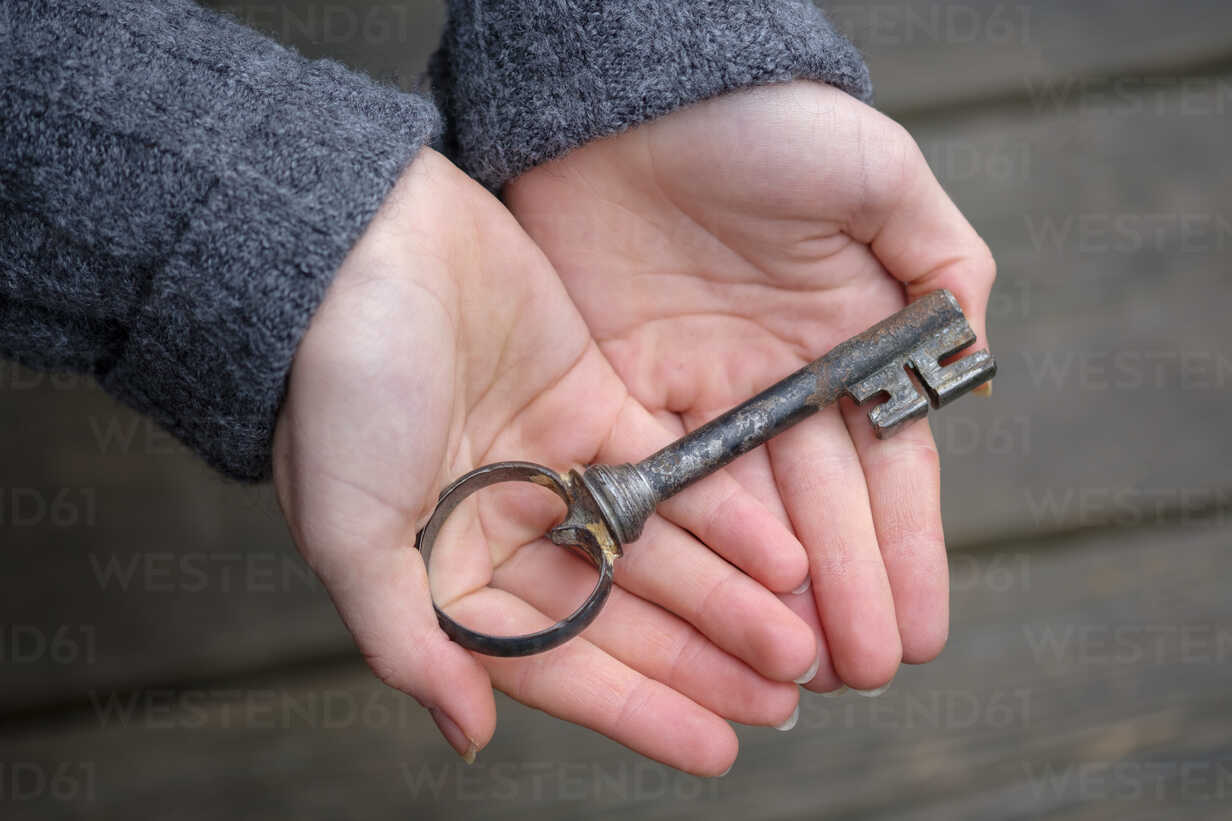 Hände, die einen alten Schlüssel halten, Nahaufnahme, lizenzfreies