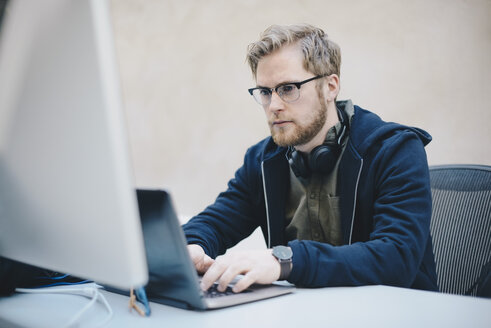 Männlicher Computerprogrammierer mit Laptop am Schreibtisch im Büro - MASF01633