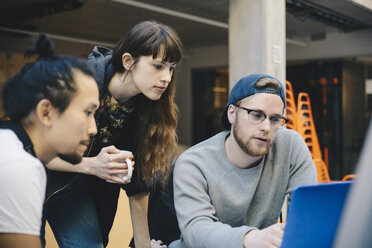 Männliche und weibliche Computerprogrammierer mit Laptop am Schreibtisch im Büro - MASF01635