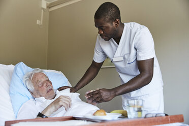 Krankenpfleger gibt Hustensaft an älteren Mann auf der Krankenstation - MASF01648