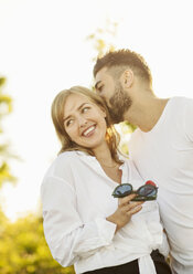 Mann küsst Freundin, während er an einem sonnigen Tag vor einem klaren Himmel steht - MASF01668