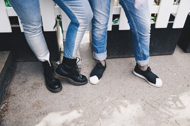 Niedriger Ausschnitt von Freundinnen, die Jeans tragen und am Zaun stehen - MASF01715