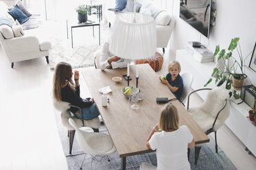 High angle view of family sitting at table in living room - MASF01727