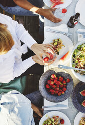 Hohe Winkel Ansicht der multiethnischen Freunde beim Mittagessen am Tisch an einem sonnigen Tag - MASF01747